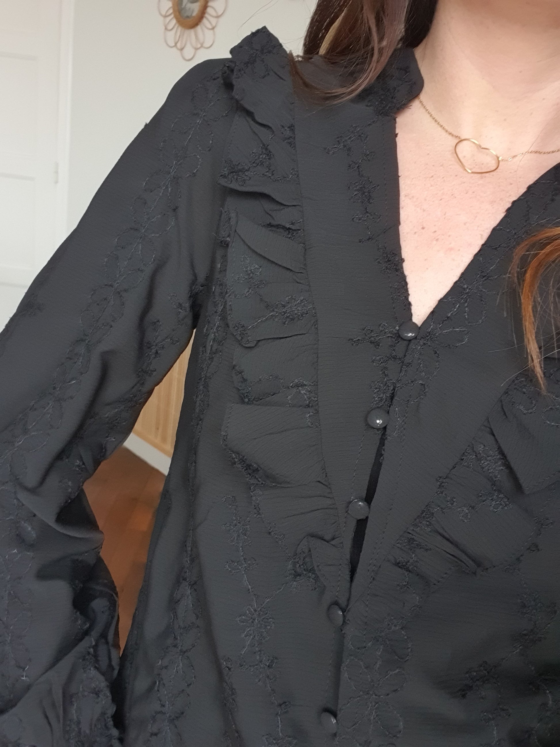 Blouse noire col en v avec détails froufrous jabot